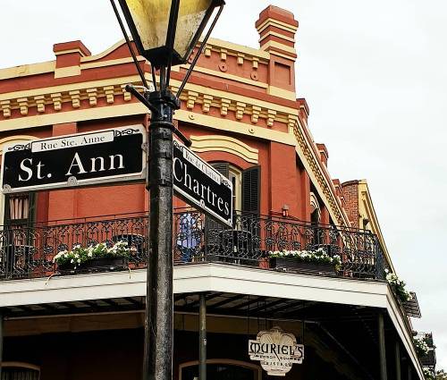 Iconic street sign indicating the corner of St. Ann and Chartres. Muriel's Bistro in the background.