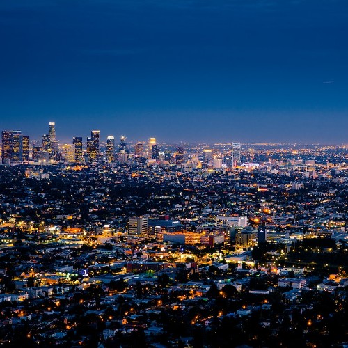 A spawling city, glimmering brightly against the twilight sky.
